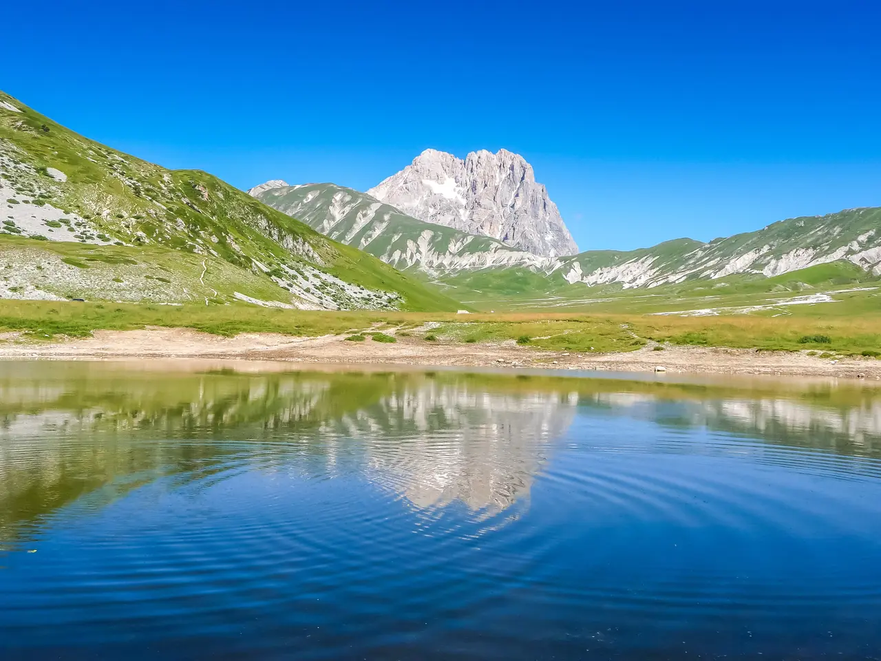 Corno Grande v pohoří Gran Sasso odrážející se v jezírku na náhorní plošině Campo Imperatore v Abruzzu