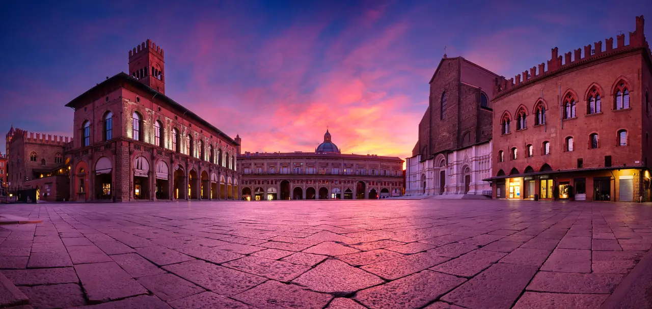 Náměstí Piazza Maggiore v Bologni při západu slunce