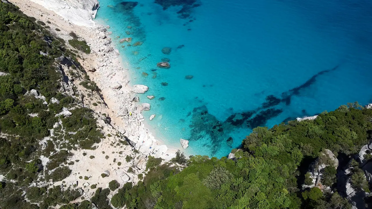 Stunning aerial shot of Cala Goloritzé, Sardinia with turquoise waters and rocky coastline.