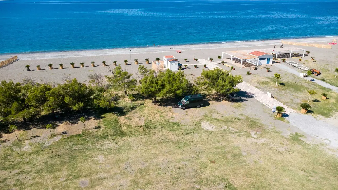 Letecký pohled na kemp Area Camper Balai Beach Club v Castrocuccu u Maratey: naše dodávka pod stromy, pláž a moře