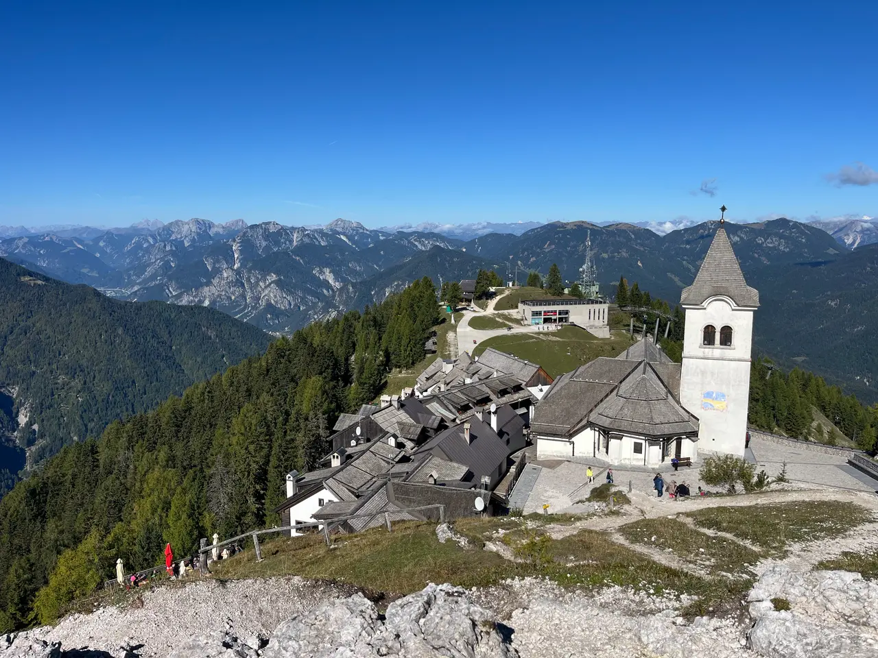 Vesnička Monte Lussari se zvonicí svatyně a pásmo Julských Alp z vyhlídky