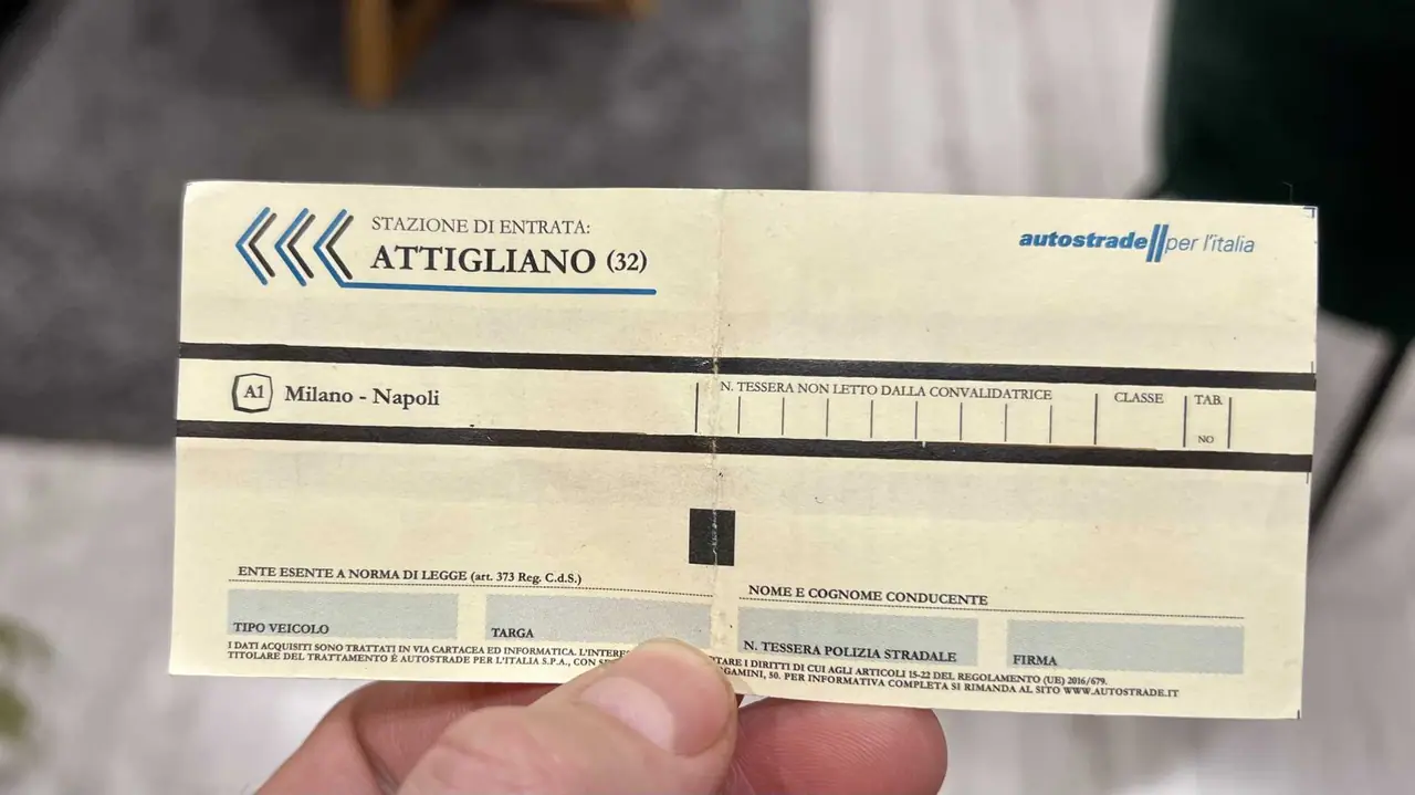 Držím v ruce mýtný lístek z dálniční stanice Attigliano na trase Milano-Napoli, důkaz naší cesty po italských dálnicích