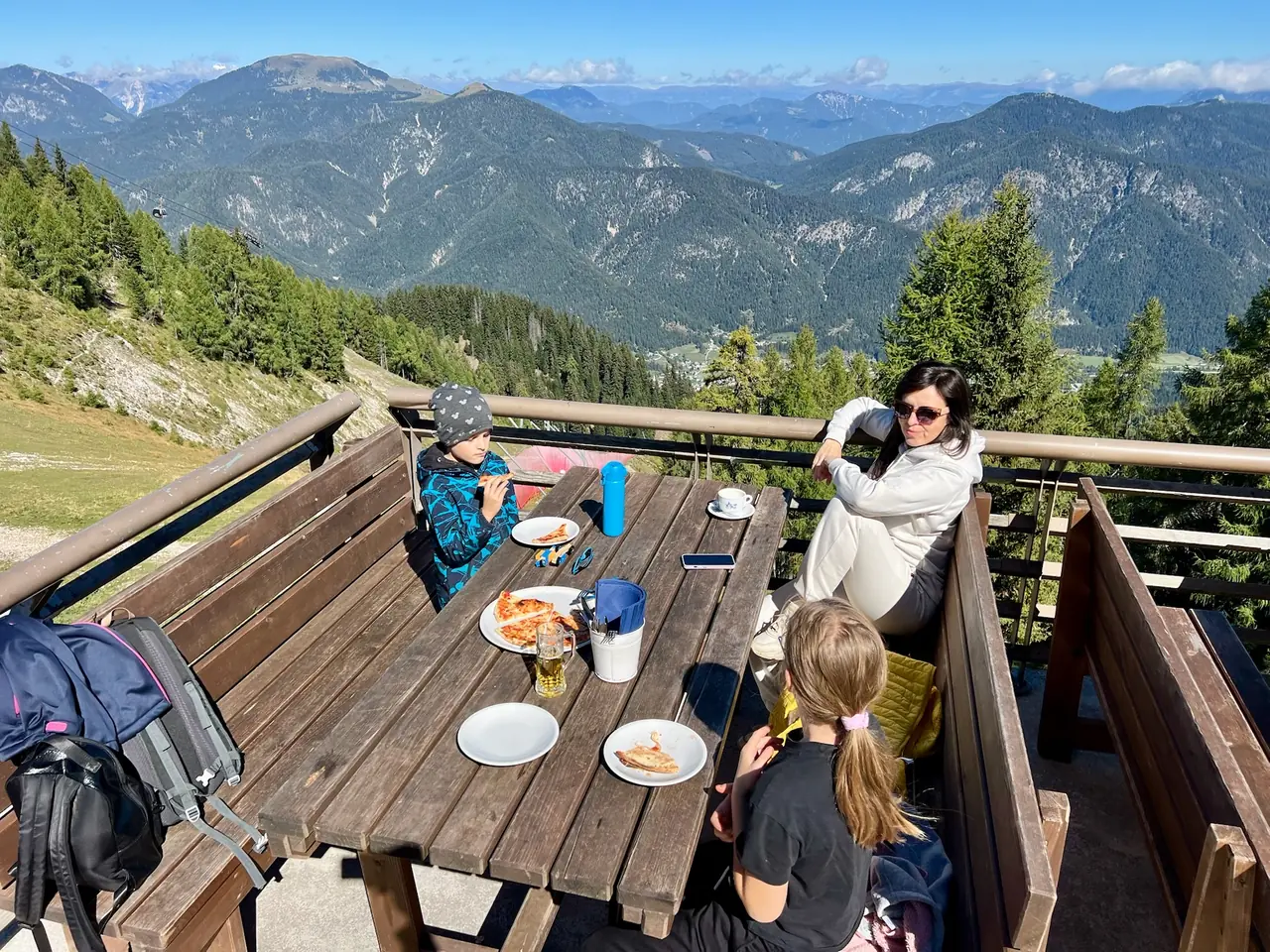 Rodinný oběd na dřevěné terase Rifugio Locanda al Convento s výhledem na hory
