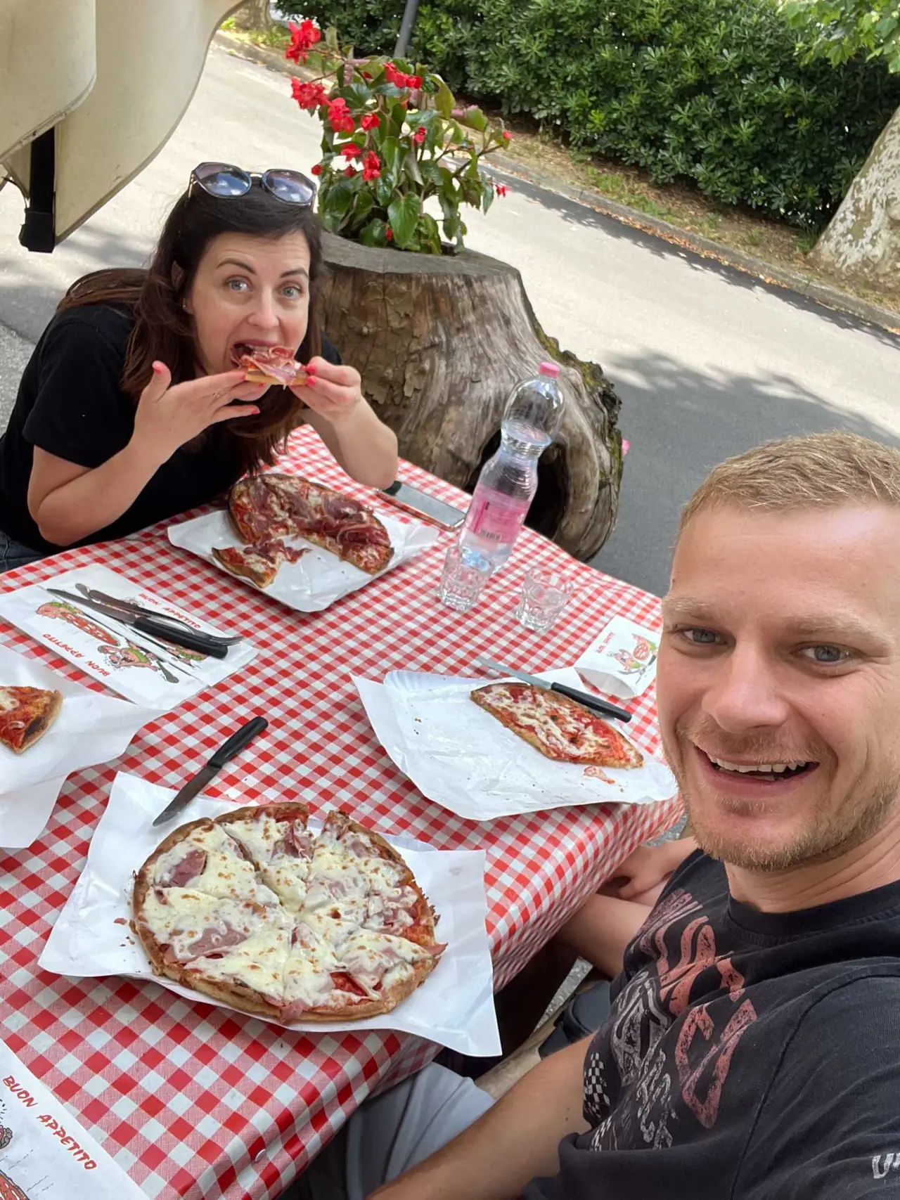 Náš společný oběd ve Fivizzanu - čerstvé pizzy na kostičkovaném ubrousku, my si pochutnáváme na autentické toskánské kuchyni pod širým nebem