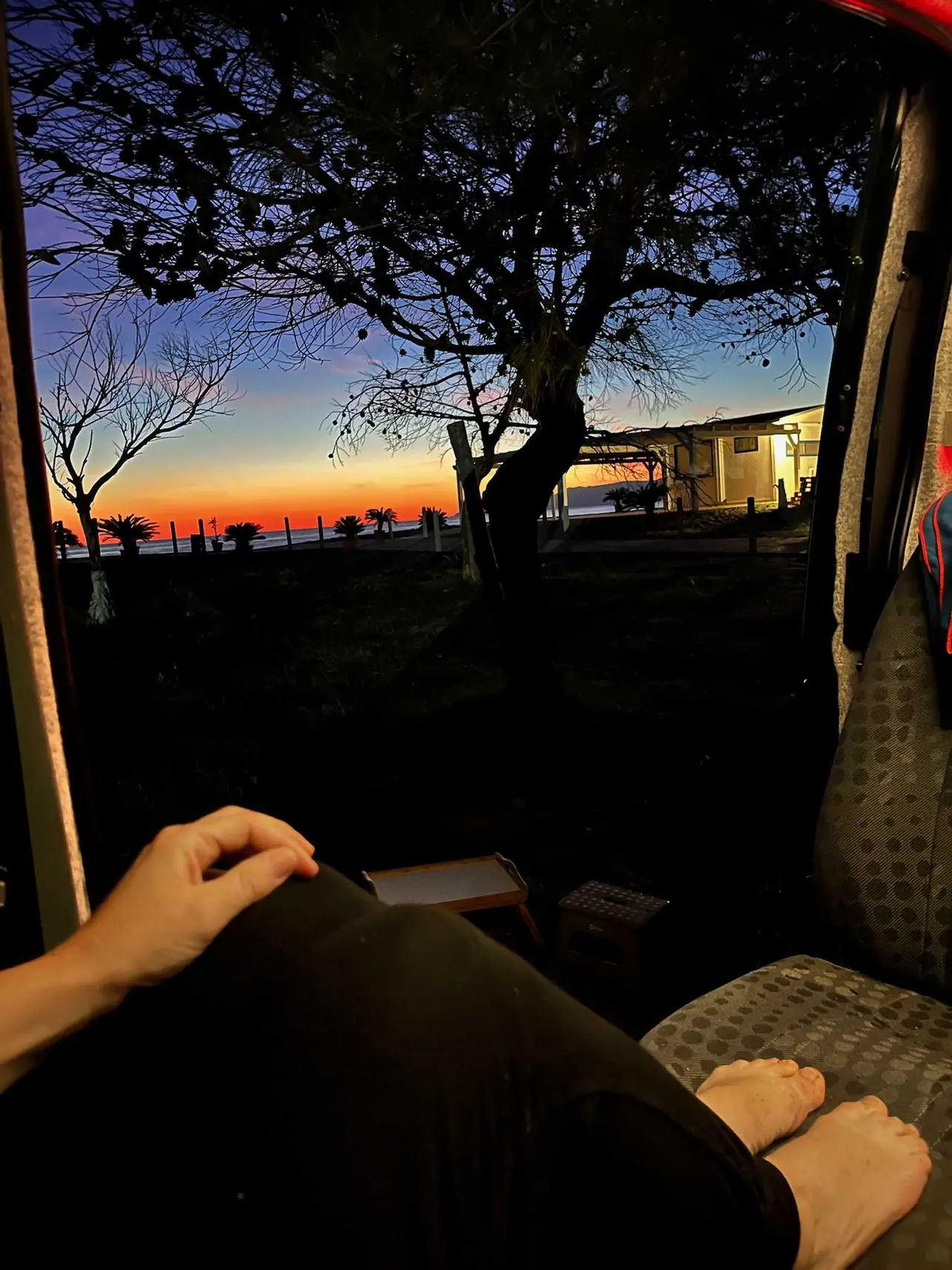 Práce na notebooku v kempu u Maratey s výhledem na soumrak nad mořem