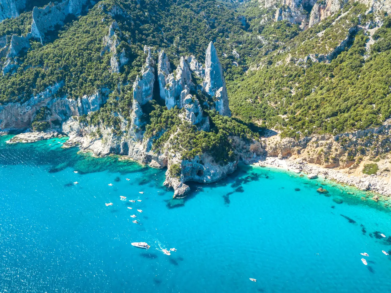 Tyrkysová zátoka Cala Goloritzè se skalní jehlou na Sardinii z dronu