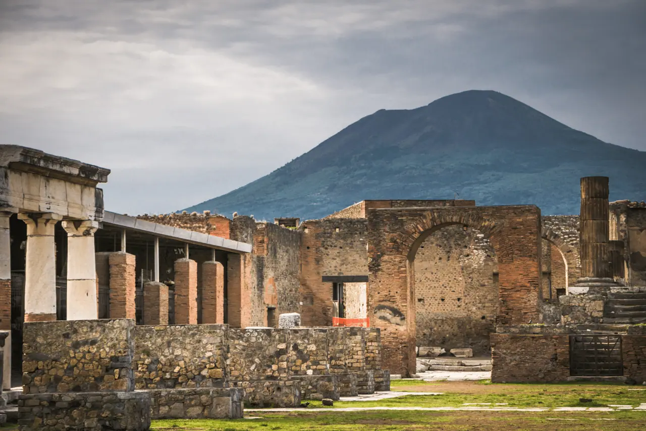 Sopka Vesuv tyčící se nad ruinami starověkých Pompejí, ikonický pohled na historii a přírodní sílu.
