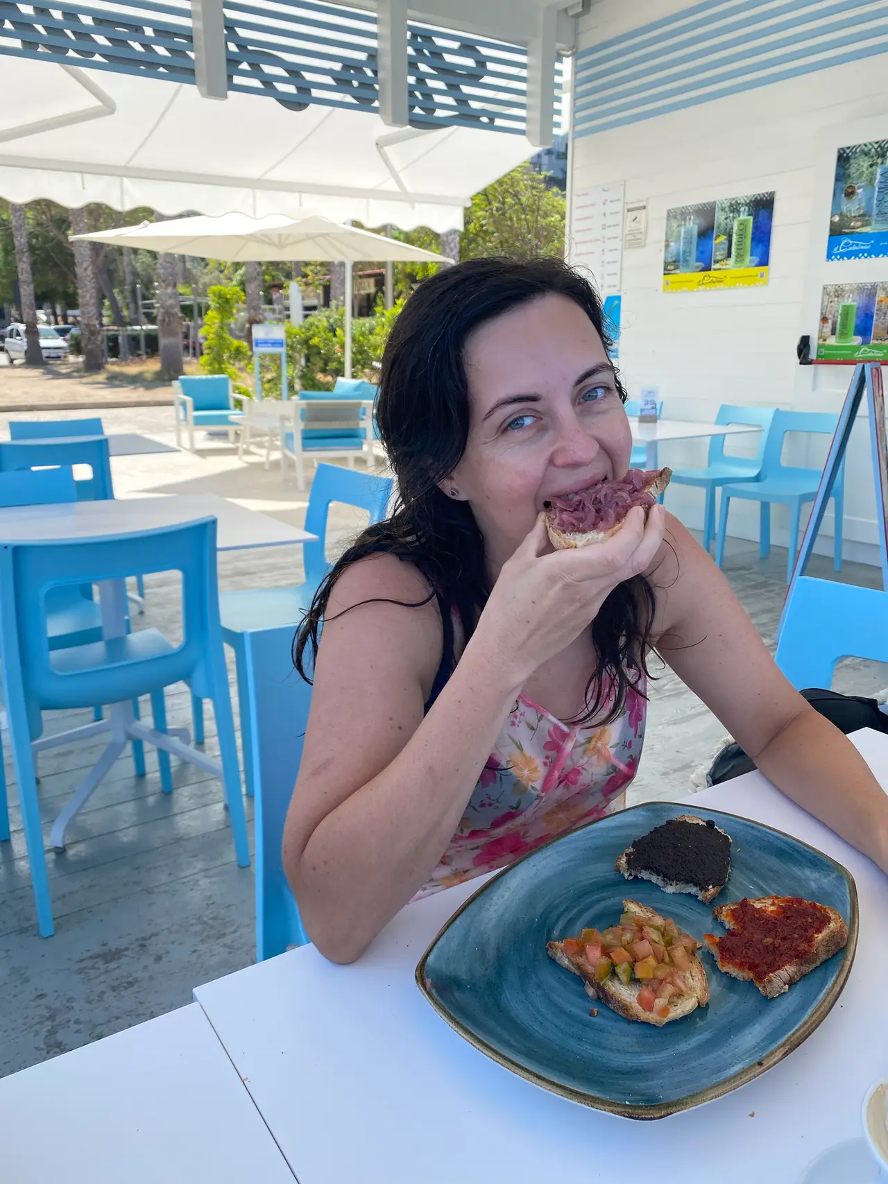 Monika u oběda v restauraci s modrými židlemi u pláže v Tropei