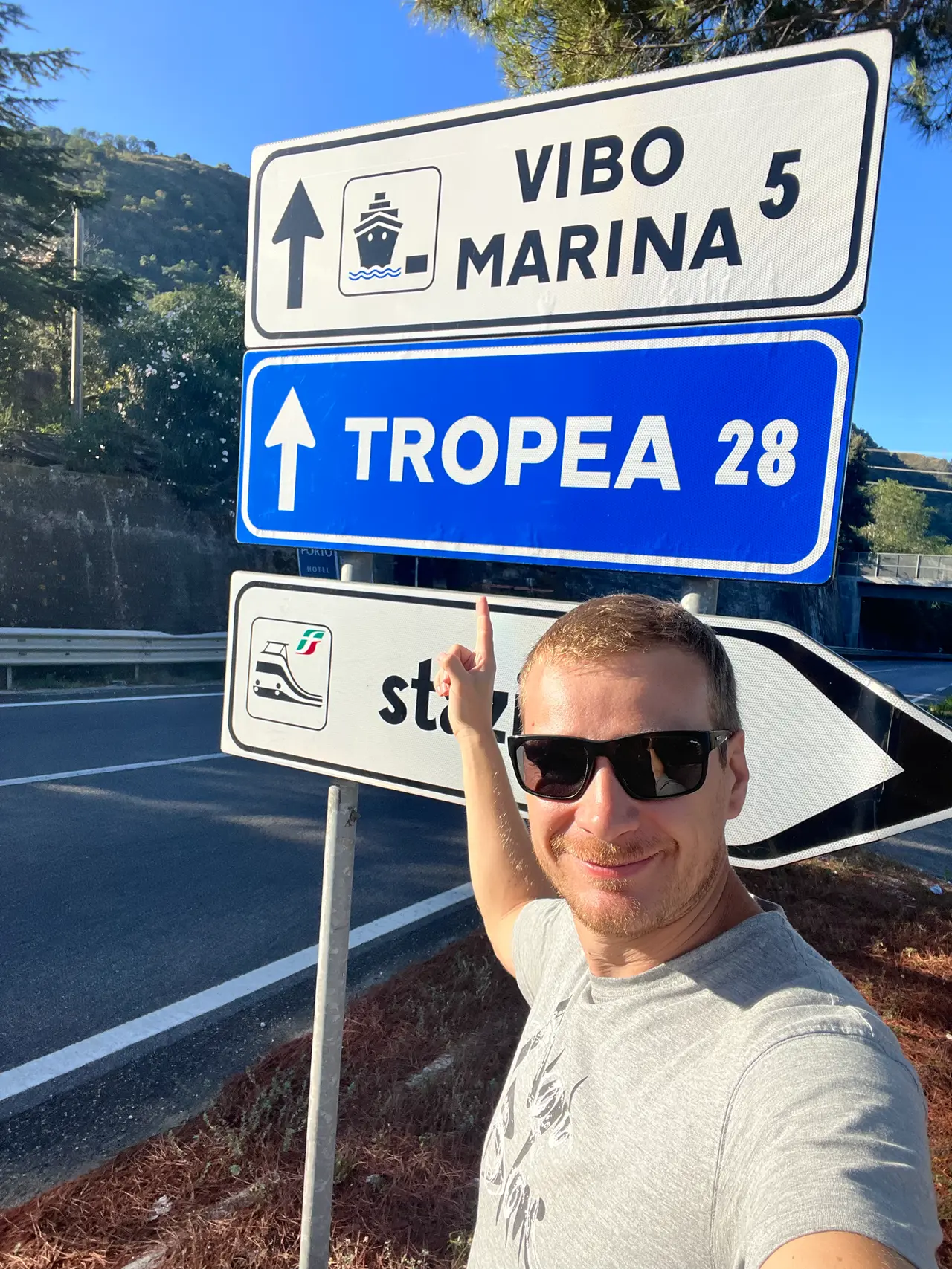Táta u silničního ukazatele Tropea 28 km na pobřeží Kalábrie