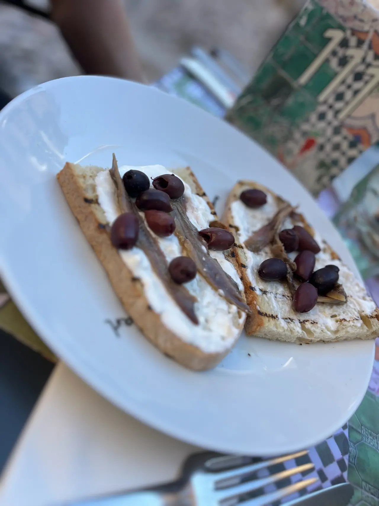 Bruschetty s olivami na talíři v restauraci v Udine