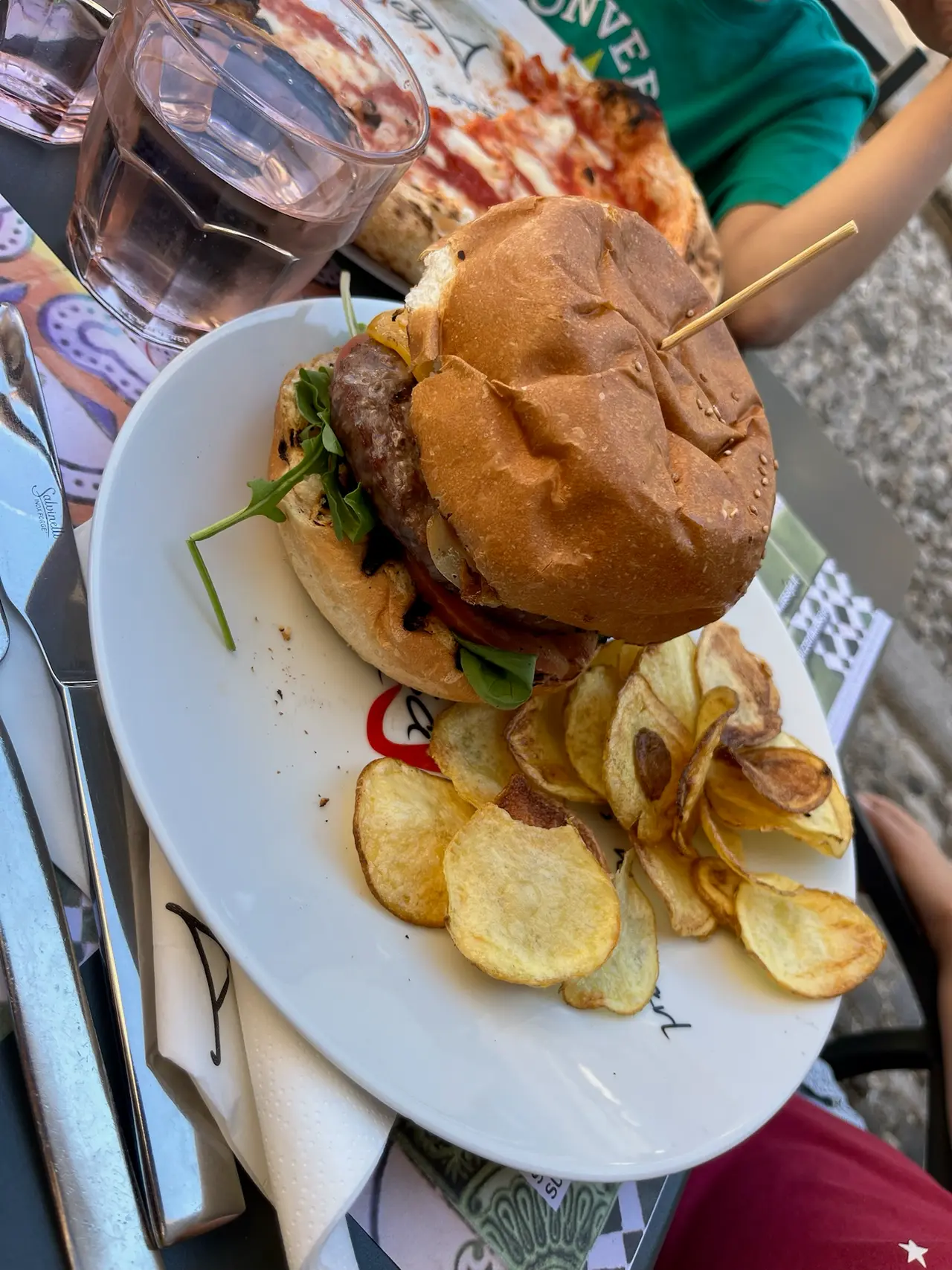 Burger s domácími chipsy na zahrádce restaurace v Udine