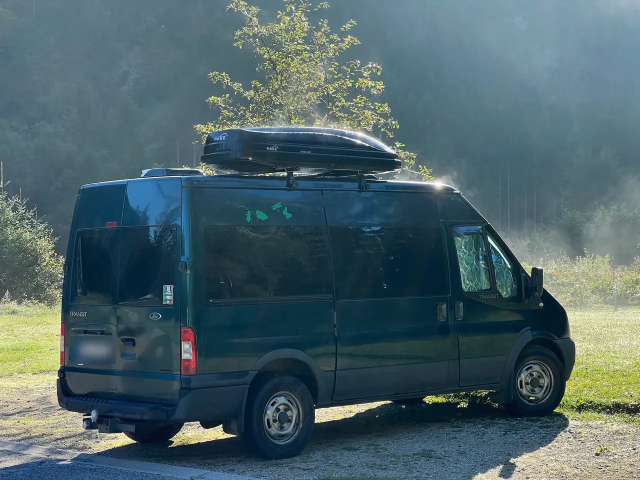 Naše zelená dodávka Ford Transit s boxem na střeše na parkovišti ve Via Saisera u Valbruny