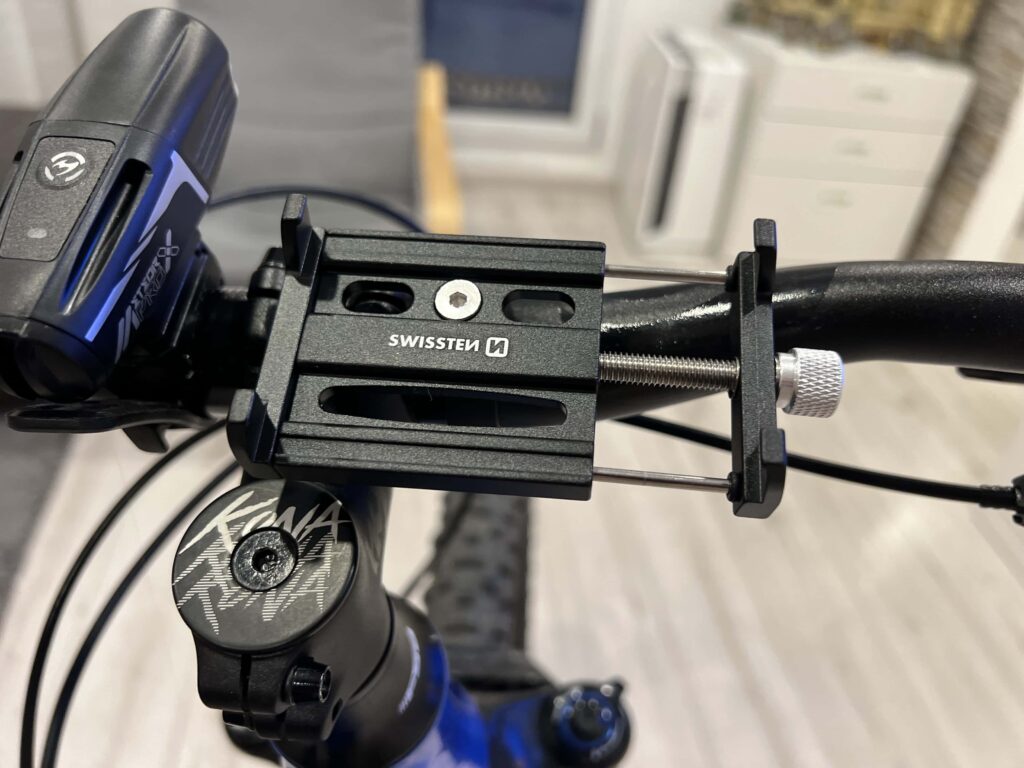 Detail kovového držáku telefonu Swissten BC2 s nastavitelným šroubem a pevným uchycením, který jsme testovali při naší recenzi