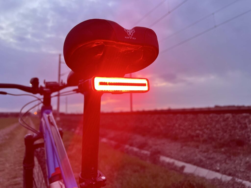 Červené zadní cyklosvětlo Moon Meteor svítí na kole při západu slunce, testovali jsme jeho výkon během naší cyklistické výpravy