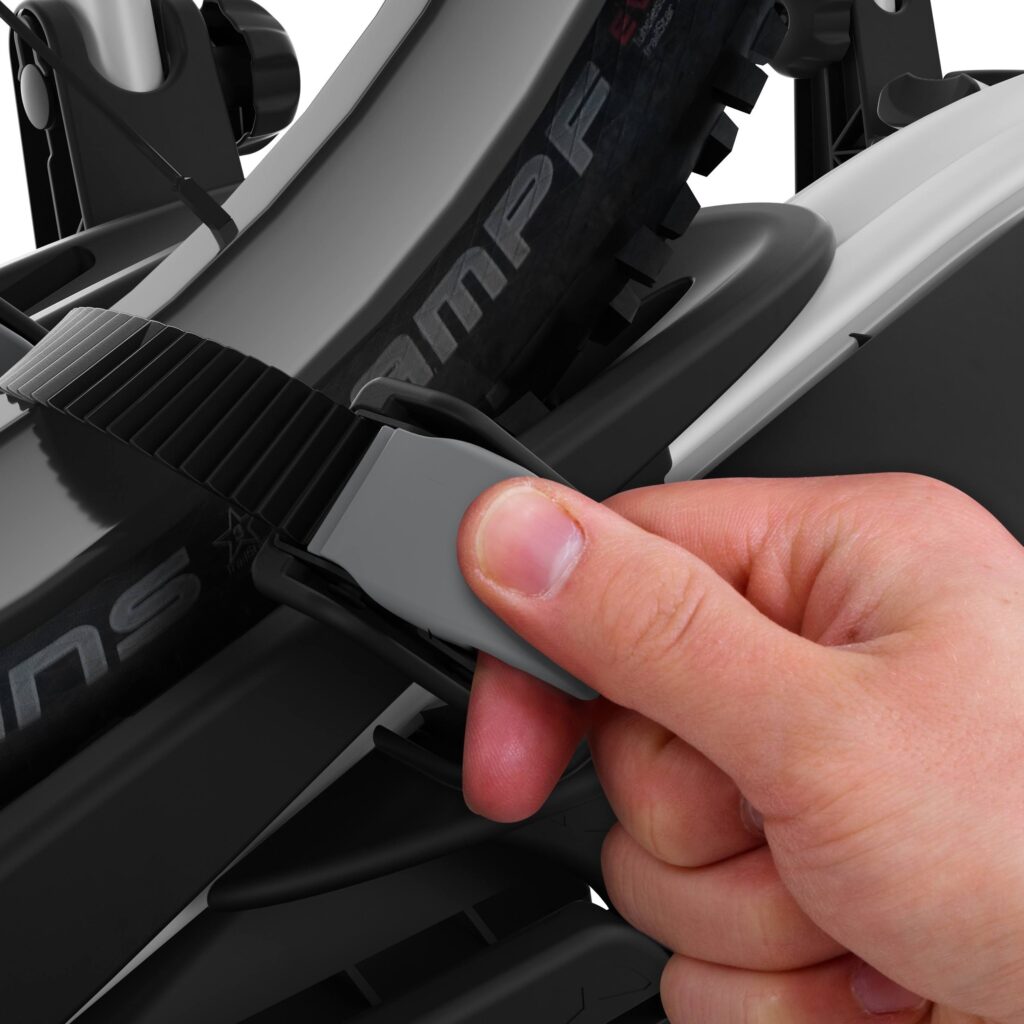 Ruka drží plastový díl při montáži nosič kol Thule VeloCompact, detail sestavování mechanismu pro uchycení na tažné zařízení