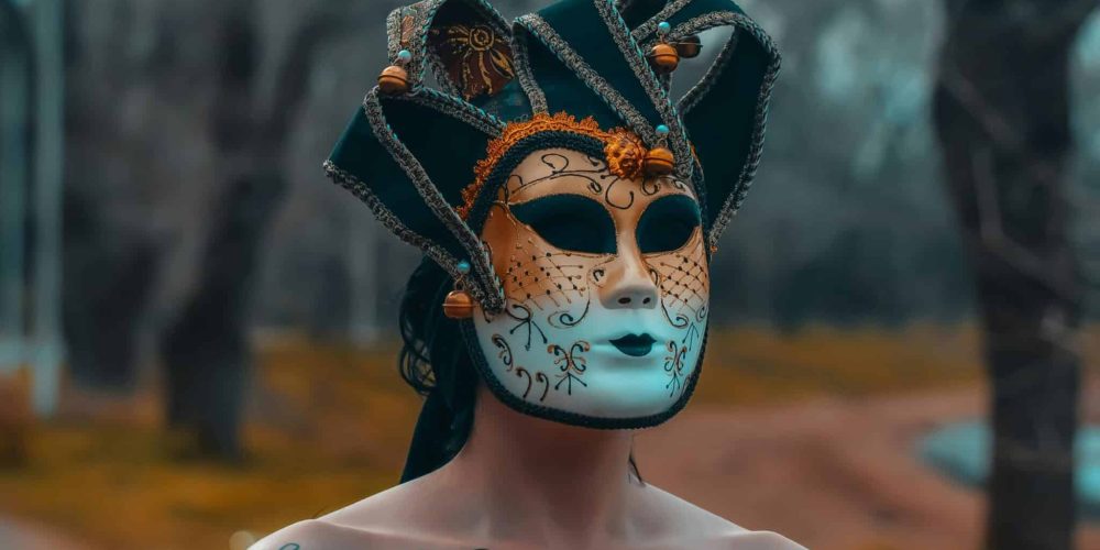 A mysterious person wearing an ornate carnival mask in a park setting in Buenos Aires.